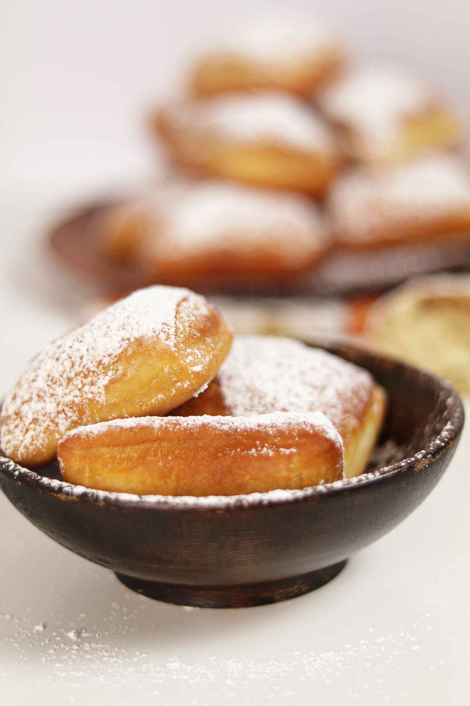 Beignets ronds et dorés, façon pets-de-nonne, roulés dans le sucre, présentés dans un bol