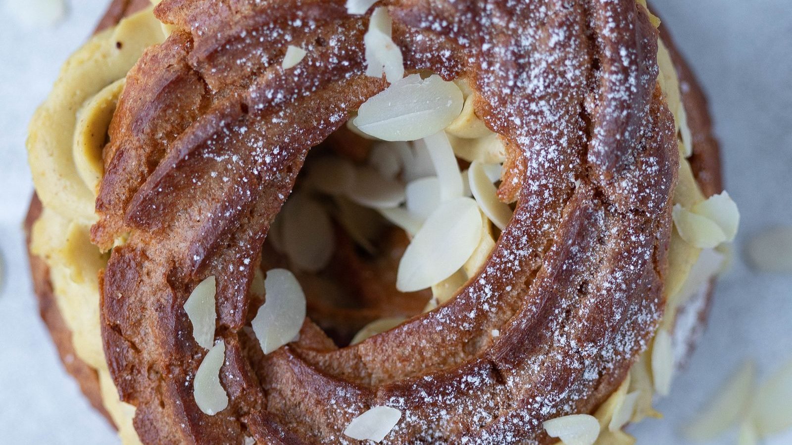 Coupe d une couronne de pate a choux montrant la garniture creme pralinee a l interieur