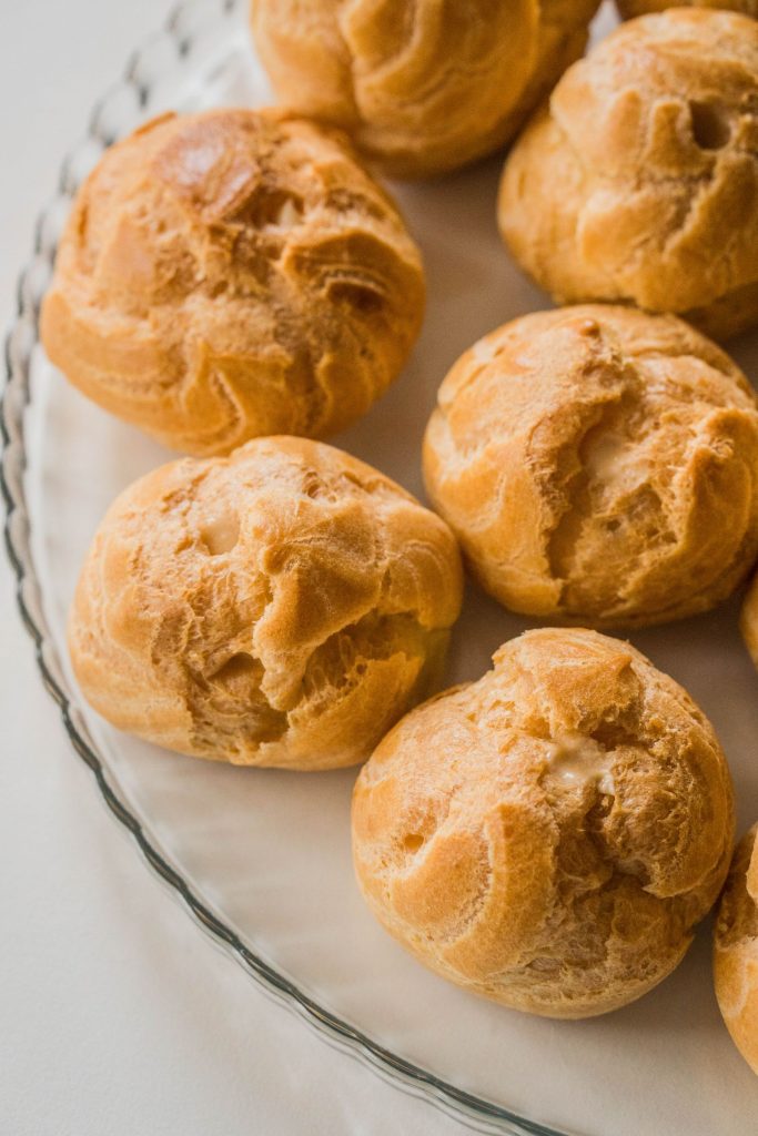 Choux à pâtisserie bien gonflés et dorés, craquelures visibles et dorées jusque dans les fissures