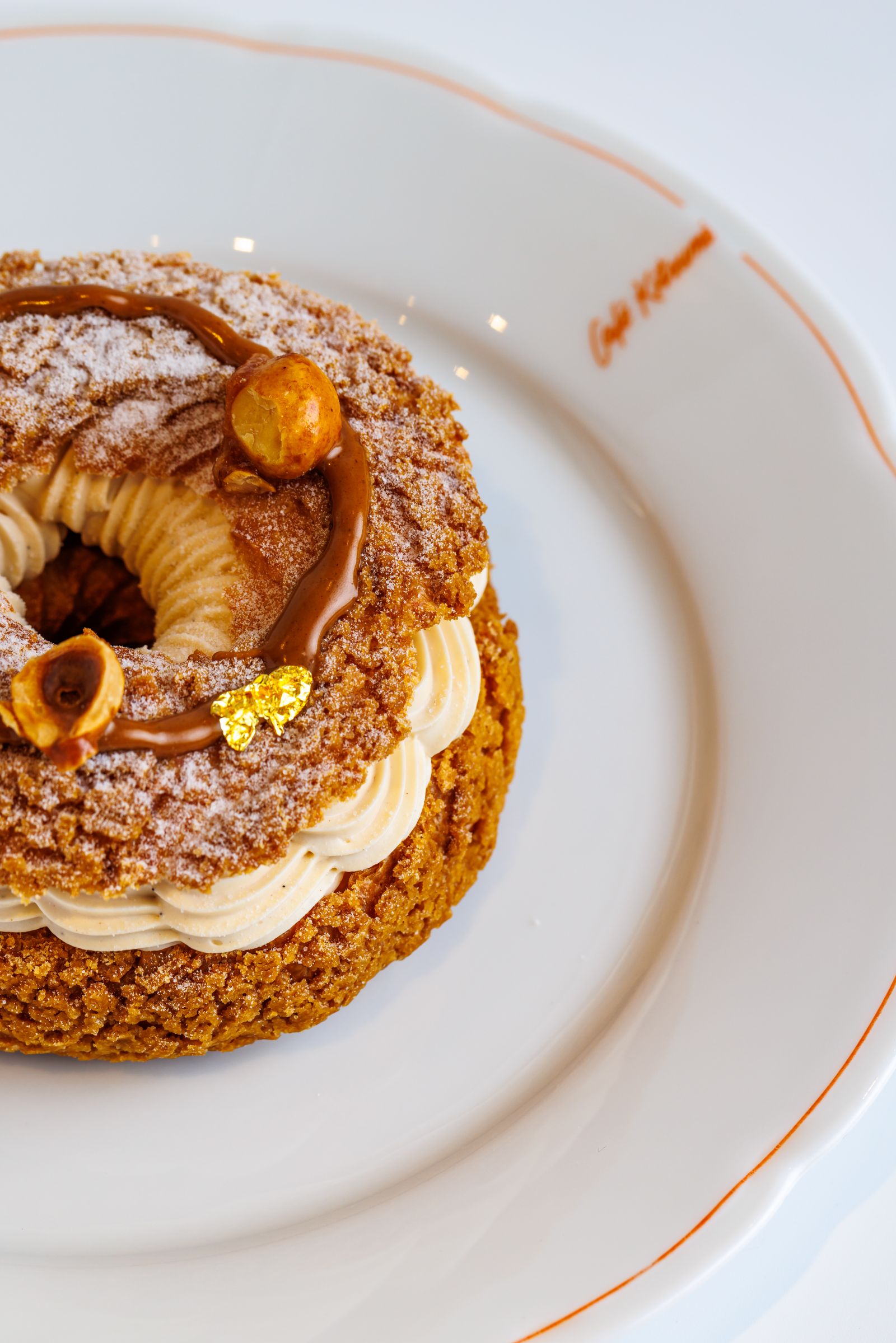 Paris-Brest garni de crème pralinée et décoré d'éclats de noisettes caramélisées