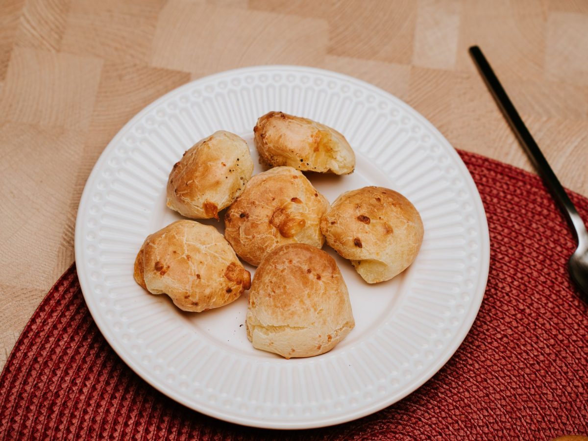 Plusieurs gougeres au comte dorees et gonflees, servies sur une assiette