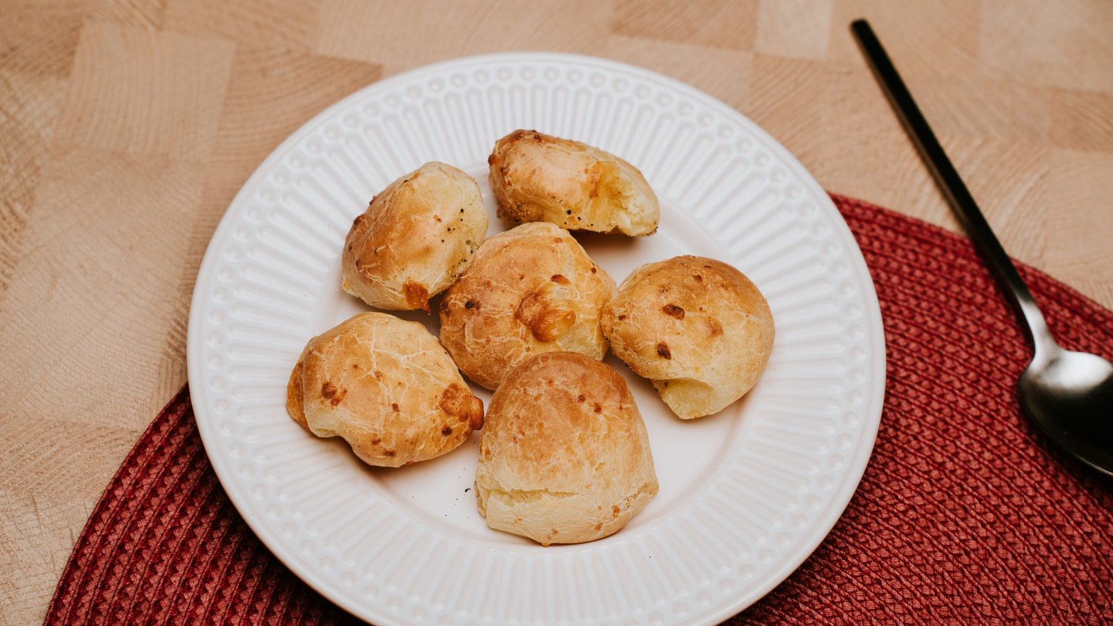 Plusieurs gougeres au comte dorees et gonflees, servies sur une assiette