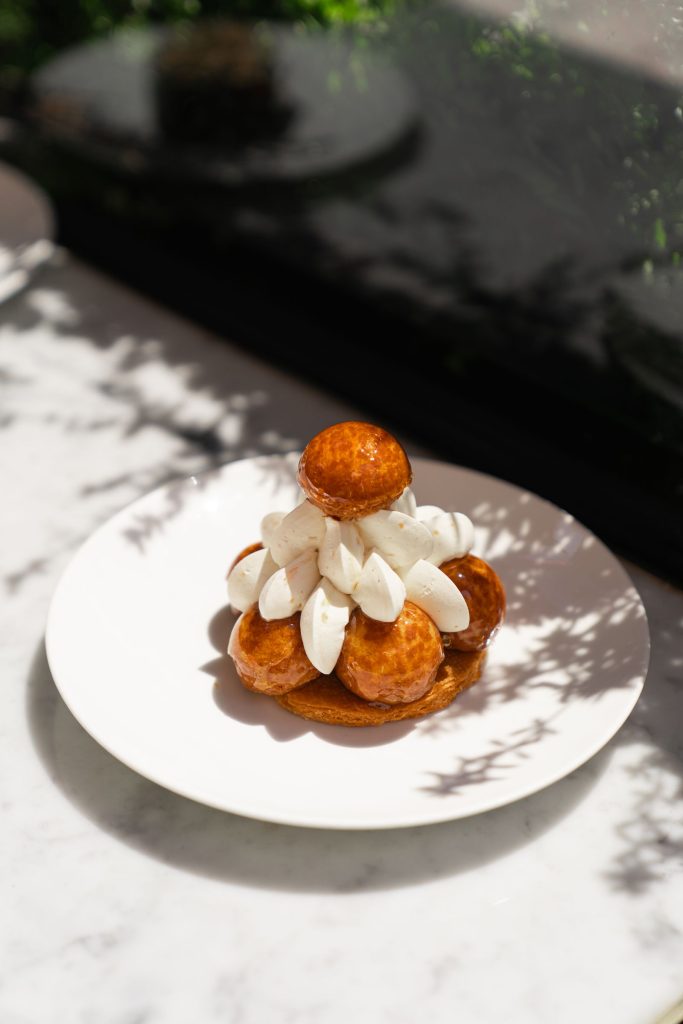 Saint-honoré monté : fond feuilleté, couronne de petits choux caramélisés et crème dressée sur le pourtour